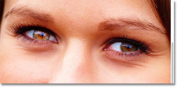 Pintar el interior del iris del ojo a la izquierda de la foto.  Imagen © 2012 Photoshop Essentials.com
