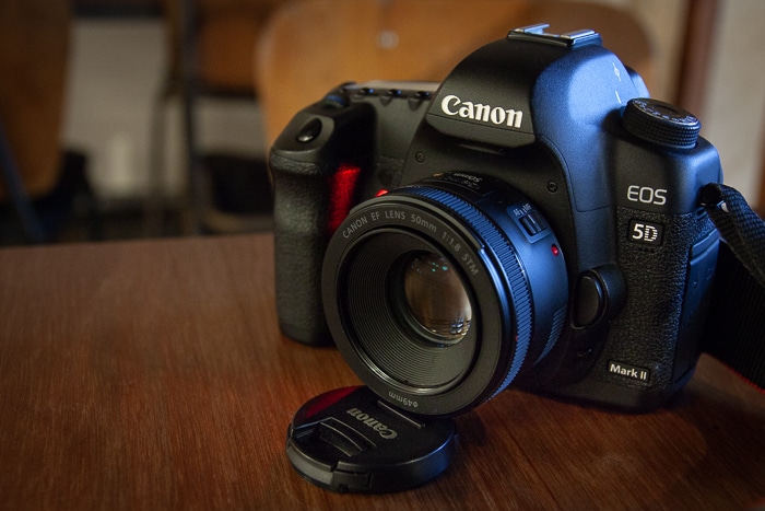 Una foto de una cámara réflex digital Canon en una mesita de café utilizada como equipo de cámara alternativo a un trípode.
