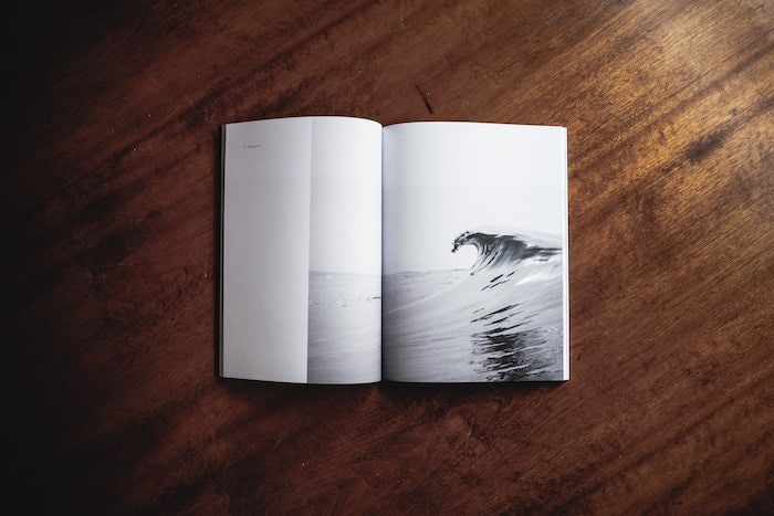 Un libro de fotos minimalista abierto sobre una mesa de madera.