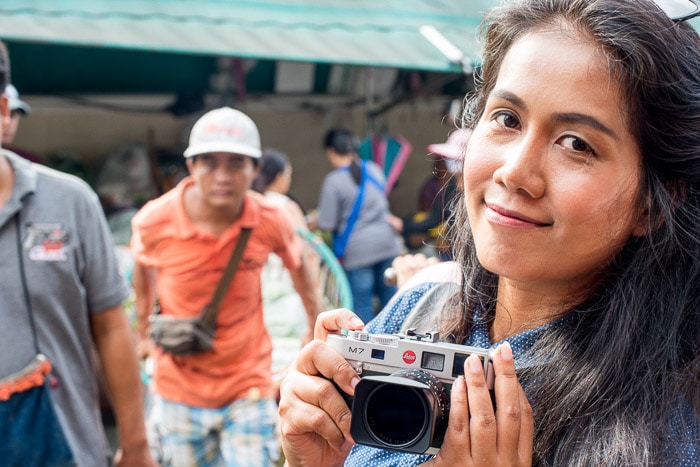 Una fotógrafa sonriendo y sosteniendo una cámara Leica m7