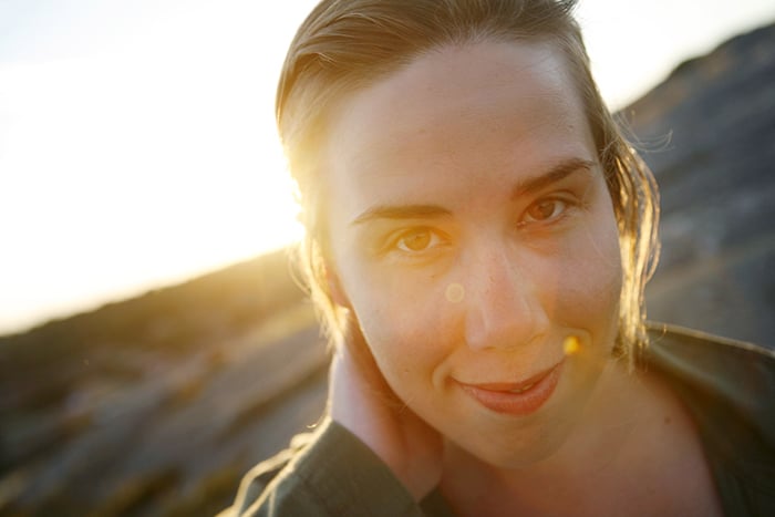 Retrato de primer plano de mujer sonriente durante la puesta de sol.