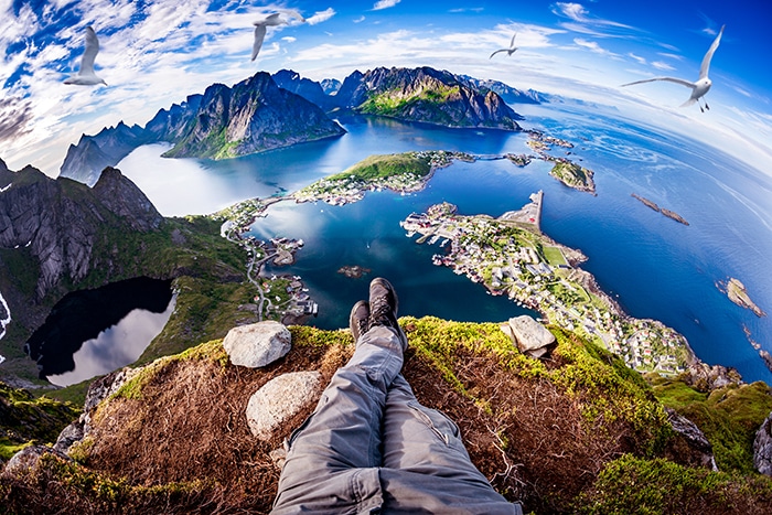 Perspectiva en primera persona tomada desde un excursionista sentado al borde de un acantilado.