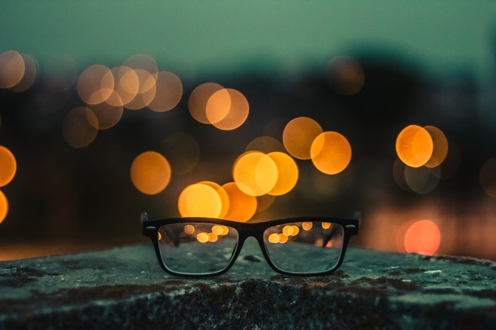 Close-up de un par de gafas con efecto de fotografía bokeh amarillo en el fondo
