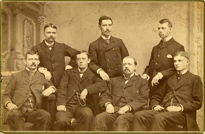 Una vieja foto grupal de siete hombres que ilustra por qué la gente no sonreía en fotos antiguas