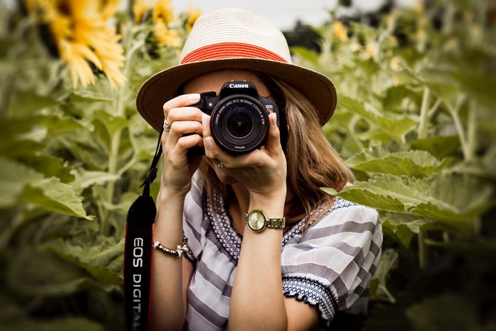 Foto de una niña tomando una foto con una cámara Canon