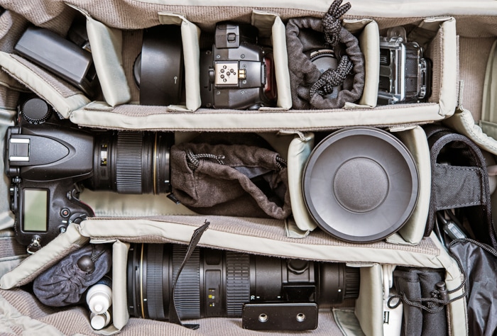 Una imagen de aparatos fotográficos y equipos fotográficos en una bolsa fotográfica.