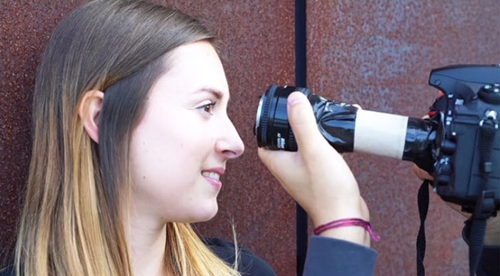 Imagen de un fotógrafo que usa una lente macro de bricolaje para fotografiar un primer plano de los ojos de una mujer