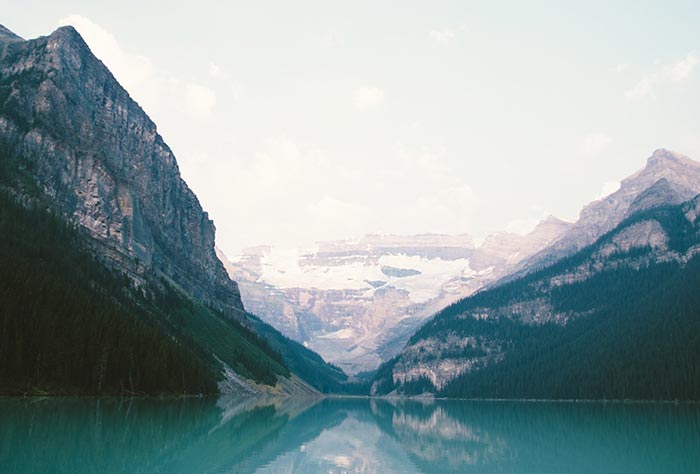 Una foto de paisaje de montañas que rodean un lago. 