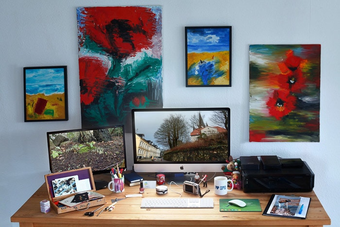 Un escritorio de oficina en casa rodeado de pinturas coloridas: modo de color en Photoshop