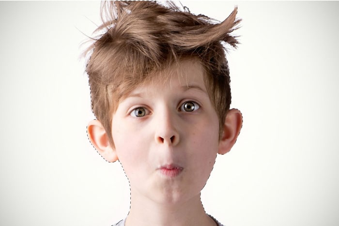 Usando Photoshop para hacer una selección de un retrato de un niño pequeño con el pelo desordenado
