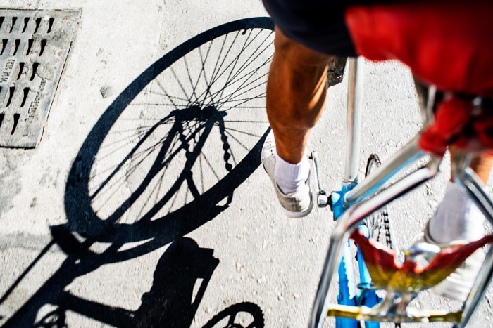 Un primer plano de las sombras proyectadas por una persona en bicicleta