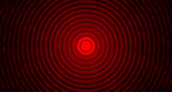 "Un disco de Airy real creado al pasar un rayo láser rojo a través de una apertura estenopeica de 90 micrómetros con 27 órdenes de difracción de lentes".