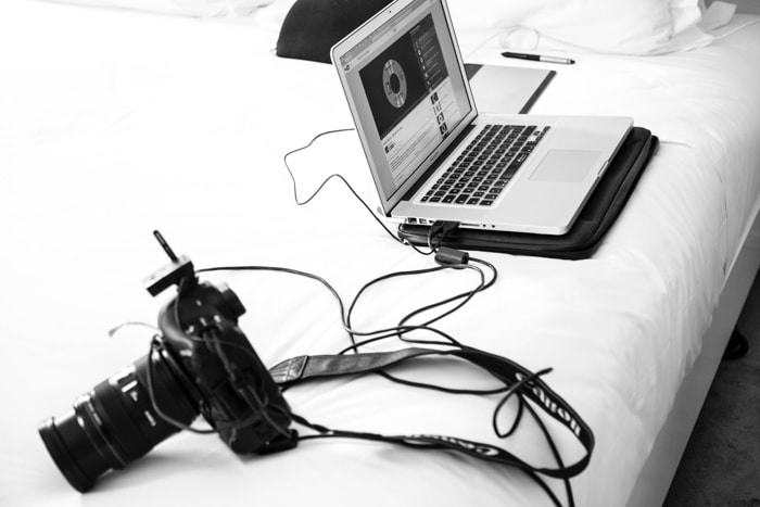 Una fotografía en blanco y negro de una cámara DSLR conectada a una computadora portátil.