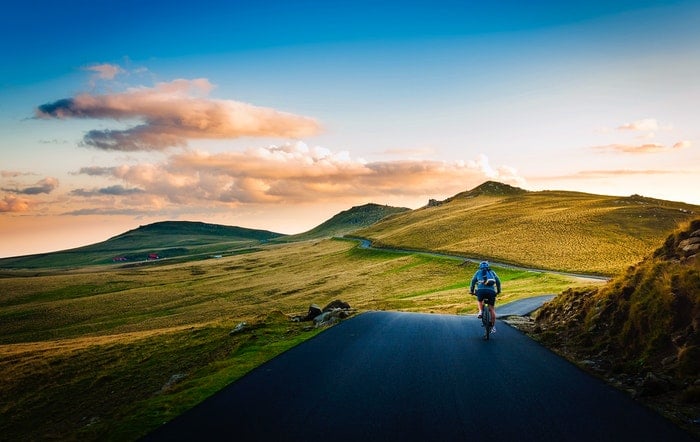 Un ciclista en una carretera en una hermosa zona rural.