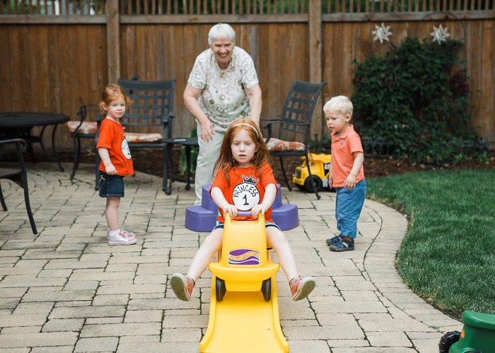 Sincero retrato de una abuela jugando al aire libre con tres nietos