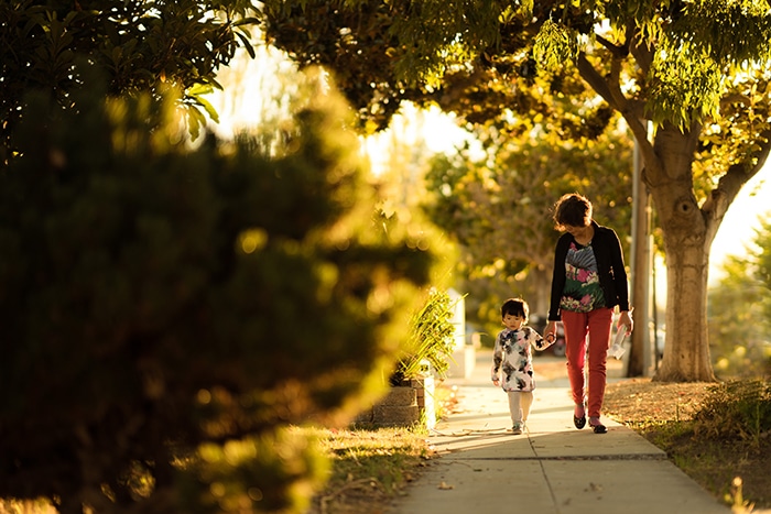 Una madre y su hijo caminando por un sendero a la luz del atardecer - consejos para retratos de estilo de vida