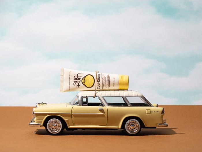 Fotografía de productos de estilo de vida con una botella de protector solar en el techo de un automóvil miniture