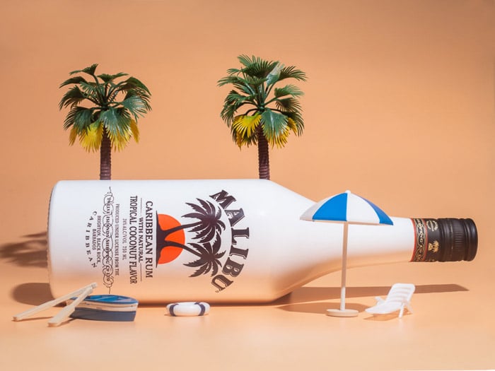 Una fotografía de productos de estilo de vida tomada de una botella de malibu contra un fondo naranja