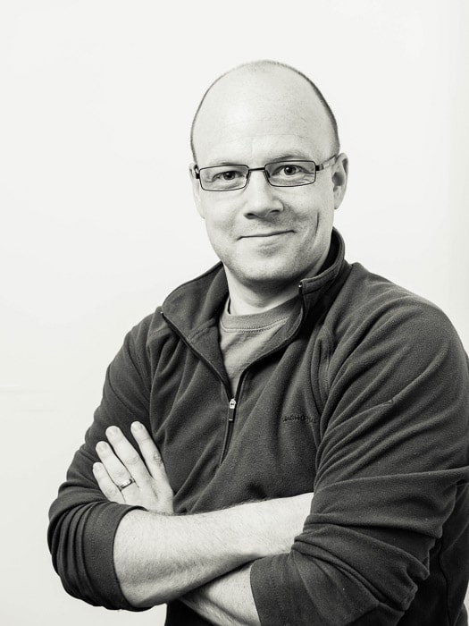 Retrato de estudio en blanco y negro de un hombre con gafas tomadas con iluminación de bucle en estudio
