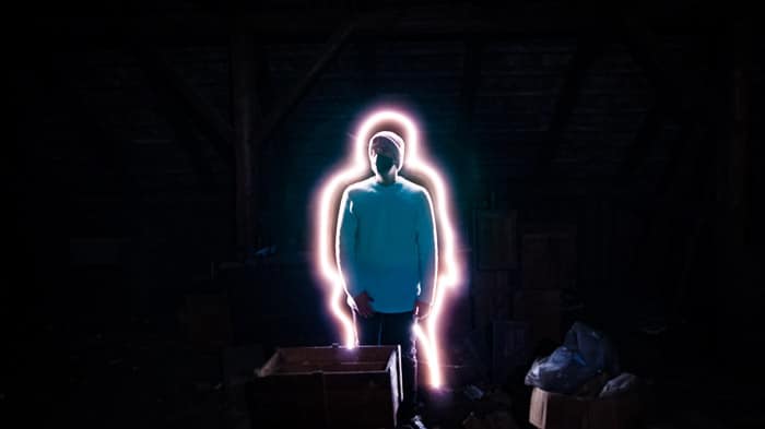 Un retrato creativo de un hombre con una línea de pintura con luz que lo rodea, filmado con herramientas de pintura con luz LED
