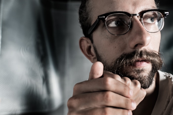 Foto de retrato de un hombre barbudo con gafas con el uso de luz clave