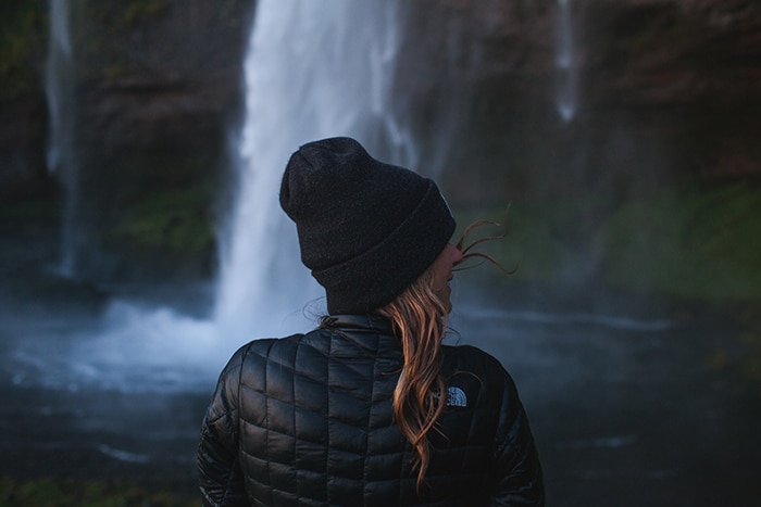 Una fotógrafa frente a una cascada en islandia