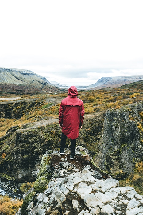 Un fotógrafo de pie sobre un rocoso en un paisaje montañoso - Lugares de fotografía de Islandia