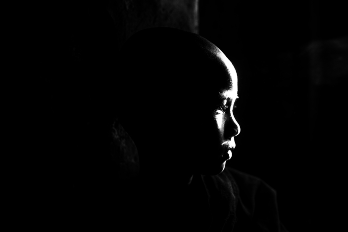Retrato atmosférico de un monje con luz reflejada que cae sobre la cara 