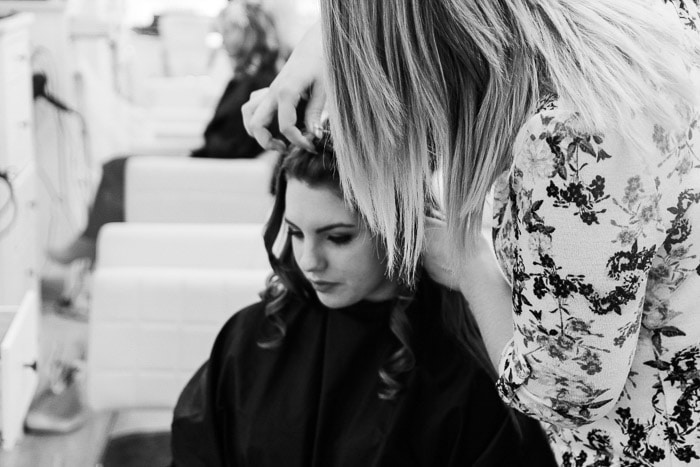 Una toma en blanco y negro de modelos de fotografía peinándose y maquillando