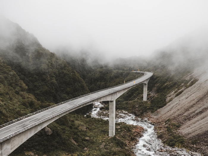 una foto de una carretera a través de montañas y niebla muestra cómo utilizar la fotografía de líneas principales