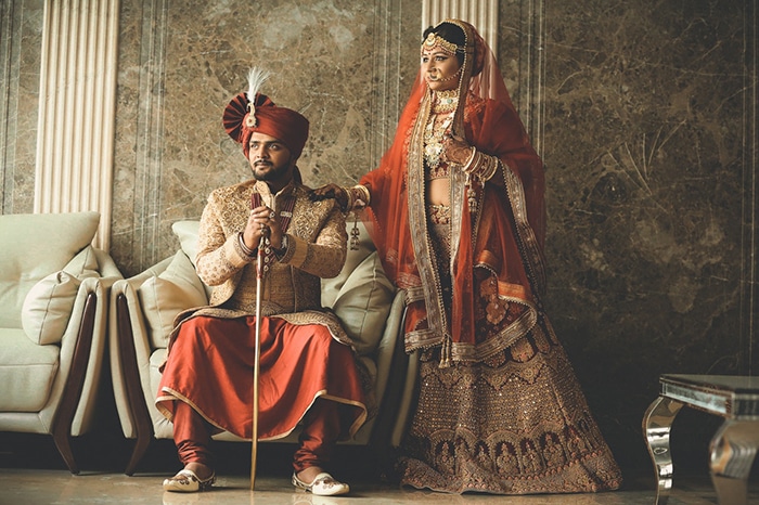 Hermoso retrato de boda de una pareja india posando en traje tradicional