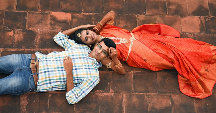 Fotografía cenital de una pareja de novios posando juntos en el suelo - Consejos de fotografía de bodas indias