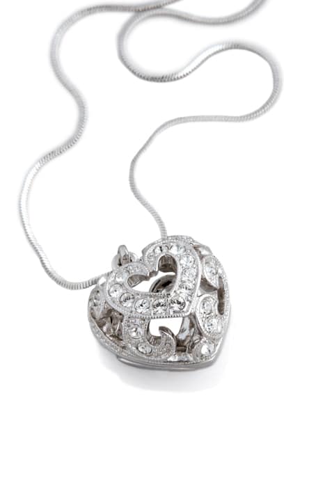 un collar de plata con una enorme medalla en forma de corazón sobre fondo blanco