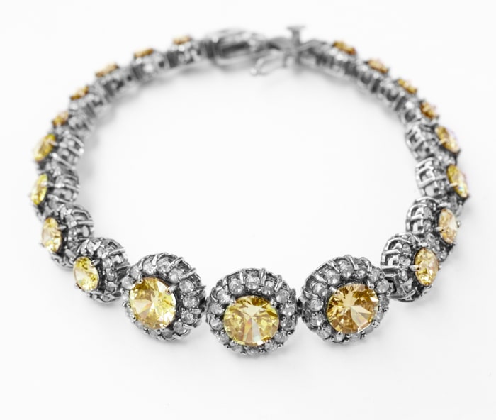 Foto de producto de joyería de un collar de plata con piedras blancas y amarillas sobre un fondo blanco