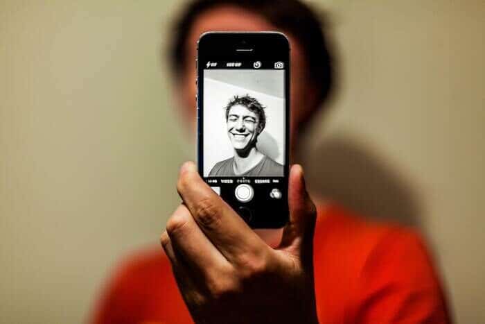 Foto de un chico tomándose una selfie usando una aplicación de cámara para iPhone