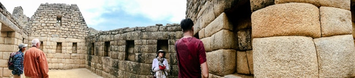 Interesantes fotografías panorámicas de turistas observando un antiguo edificio de piedra.