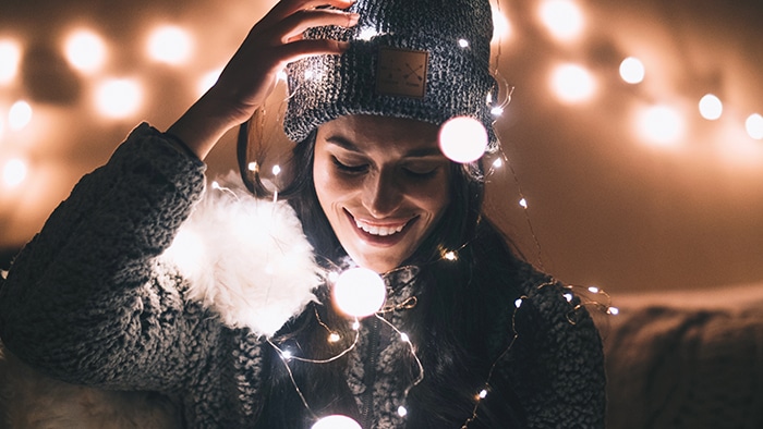 Una chica posando en el interior con luces navideñas y hermosos efectos bokeh