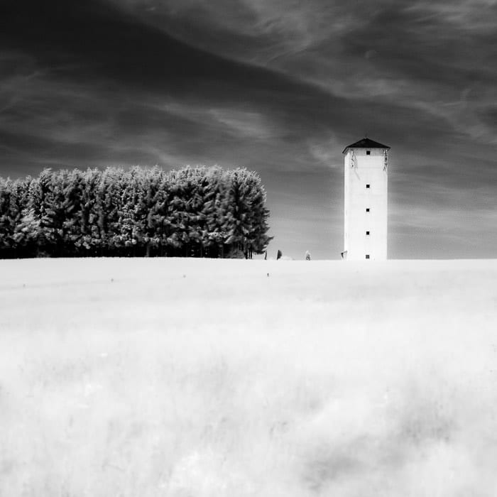 Una toma de fotografía infrarroja de una torre en el campo, que demuestra la simetría en la fotografía
