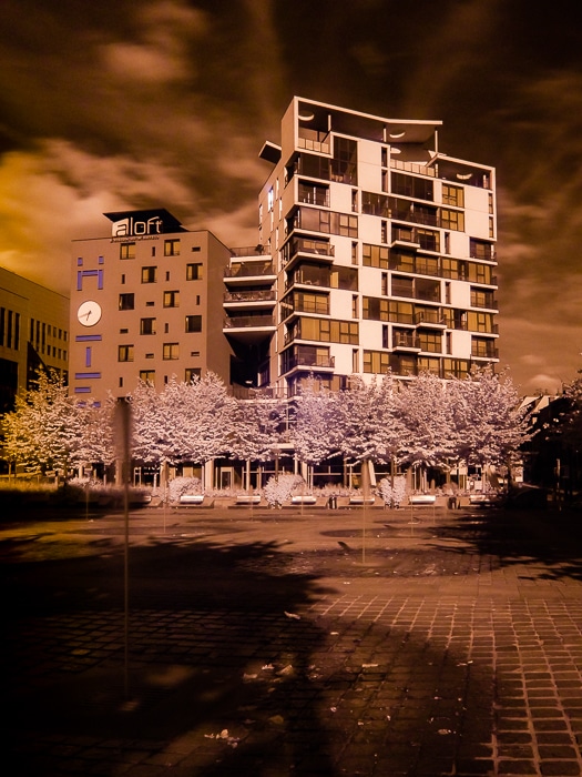 Una imagen infrarroja en falso color del exterior de un gran edificio en tonos naranja.