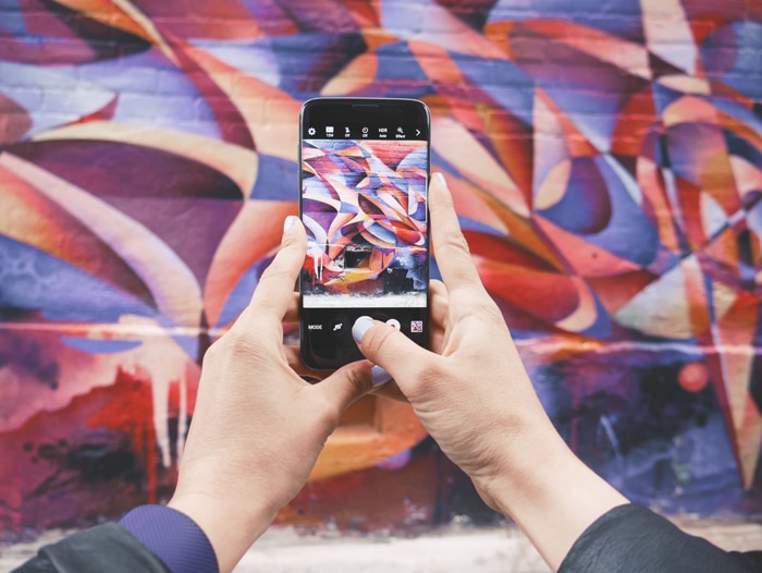 foto de alguien que toma una foto de una pared colorida con un teléfono inteligente