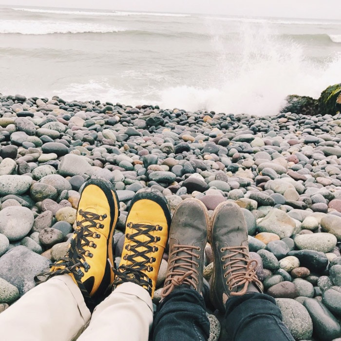 Paisaje de playa con los pies de dos personas en primer plano.  Consejos de Instagram para principiantes en fotografía.