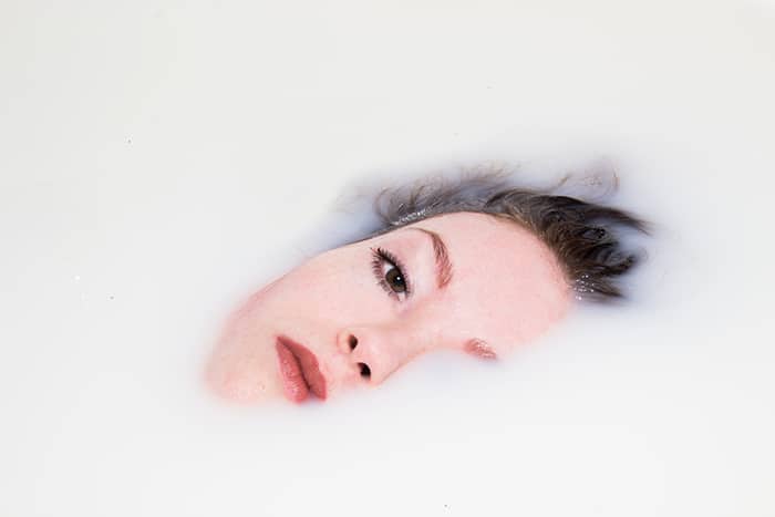Un baño de leche de cerca la fotografía retrato de un modelo femenino sumergido en leche