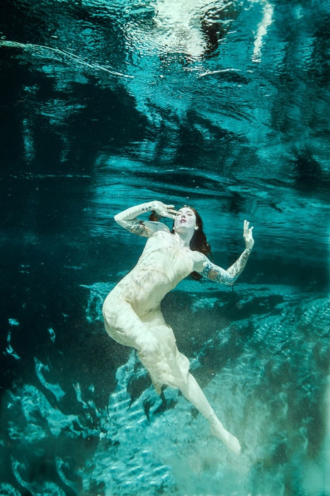 Una mágica sesión de fotos de sirenas bajo el agua con una modelo femenina posando bajo el agua