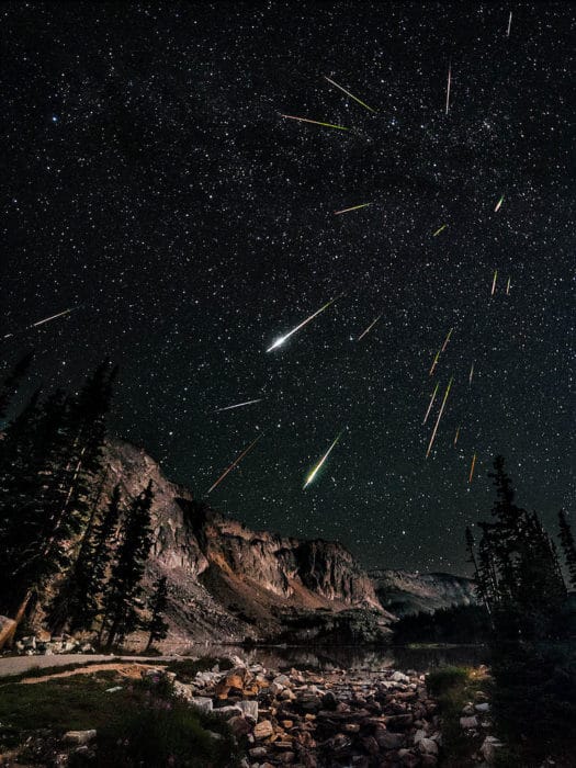 Un bonito paisaje nocturno que muestra muchos meteoritos acercándose a la fotografía, añadiendo una sensación 3D a la imagen.