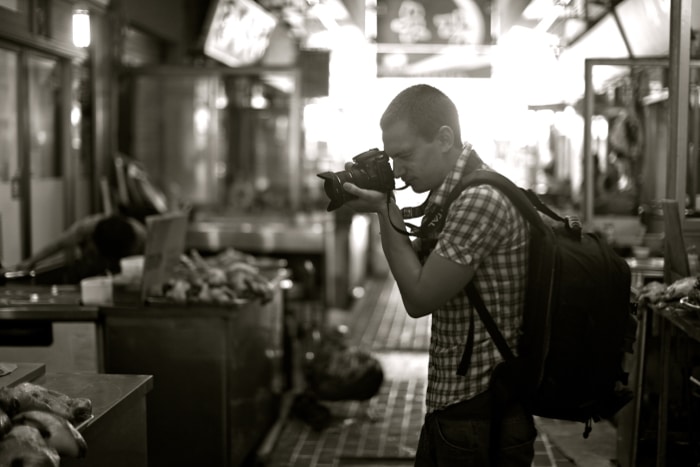 Un fotógrafo con cámara y mochila.