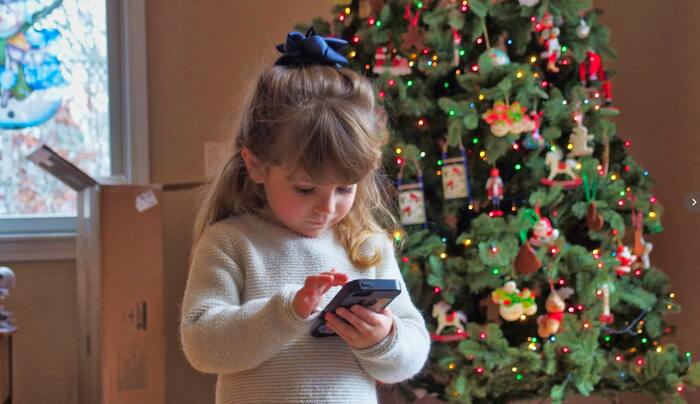foto de una niña frente a un árbol de navidad