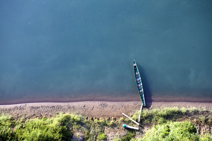 Una vista aérea de un pequeño bote en un paisaje costero mínimo.