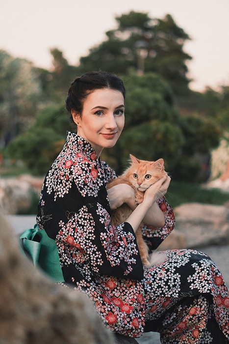 un retrato minimalista de una modelo femenina sosteniendo un gato