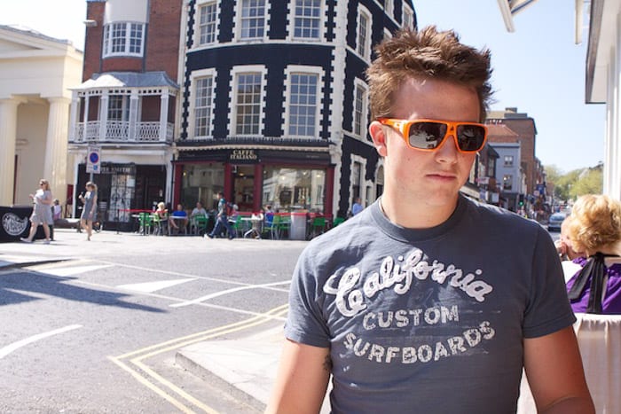 Un retrato de un hombre con gafas de sol posando en una calle de la ciudad, filmado sin usar un filtro polarizador