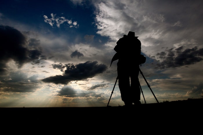 Una silueta de un fotógrafo con un trípode.